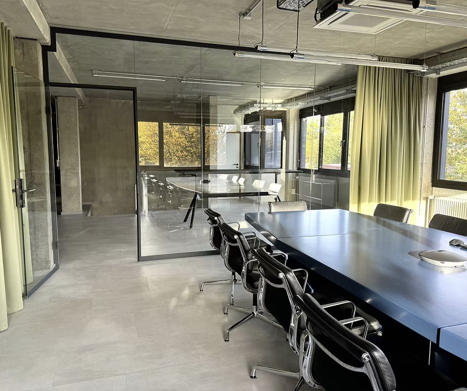 Besprechungsraum im Büro von RLS Immobilien mit langem Konferenztisch und Glaswänden